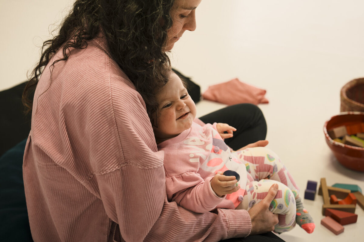 Mãe segurando a bebê no colo, em momento de vínculo durante o encontro